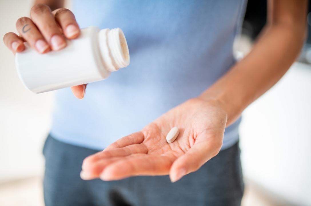 woman holding selenium supplements for a vegan diet